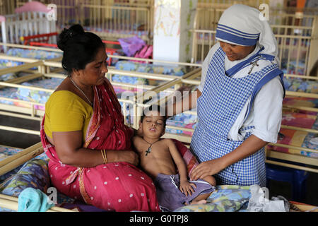 Teresa Suor cura un ragazzo malato nel 'Nirmala Shishu Bhawan Childrens Home' delle Missionarie della Carità (Madre Teresa sorelle) in Calcutta, India Foto Stock