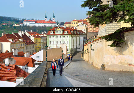 Praga, Repubblica Ceca. I turisti a piedi fino Ke hradu - strada che conduce dal castello di Nerudova. Torri del Monastero di Strahov b Foto Stock