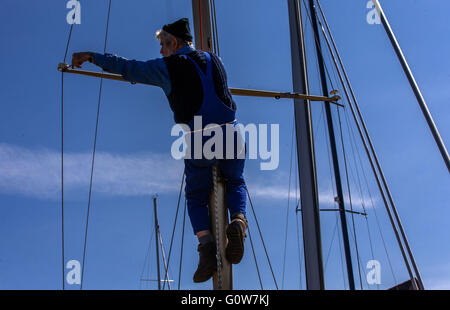 Greifswald (Germania). 04 Maggio, 2016. Herbert Howe si arrampica il montante di una storica barca vela e rig il montante nel museo cantiere di Greifswald dopo la barca è vacanza invernale a Greifswald, Germania, 04 maggio 2016. Un totale di 16 marinaio storiche imbarcazioni di peso da 400 kg a 30 tonnellate sarà sollevato nel Baltico di acqua di mare con una gru mobile dopo la pausa invernale. La maggior parte delle tradizionali imbarcazioni a vela sarà fare gite a mar Baltico o le acque di Bodden nei prossimi giorni. Foto: Jens BUETTNER/dpa/Alamy Live News Foto Stock