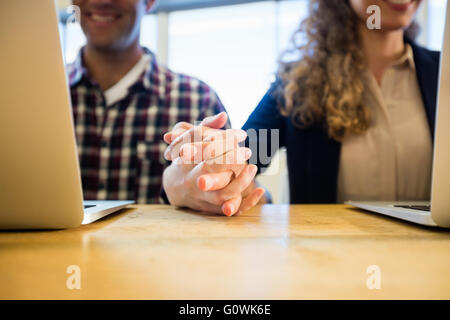 I colleghi tenendo le mani Foto Stock