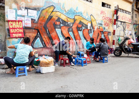 Persone mangiare sulla strada di Hanoi, Vietnam Foto Stock