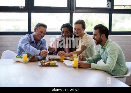 Sorridente team di business persone aventi il pranzo Foto Stock