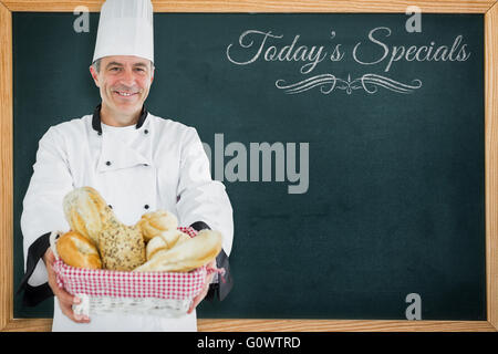 Immagine composita di chef sorridente e tenendo un cestino per pane Foto Stock