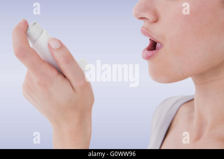 Immagine composita del soggetto asmatico bella bruna mediante inalatore Foto Stock