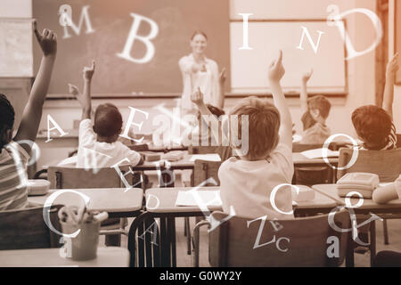 Gli alunni ad alzare la mano durante la lezione Foto Stock