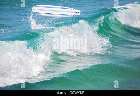 Surfer gambe in acqua e il surf board in aria dopo la caduta di un'onda. Foto Stock