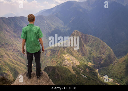 Un turista di Machu Picchu è di montagna che guarda la misteriosa città Inca di 600m sotto - Machu Picchu, Perù nel mese di ottobre 2015 Foto Stock