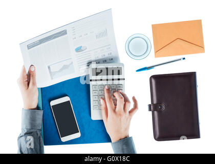 Business donna lavora alla scrivania, controllo una relazione finanziaria e calcolare i saldi su sfondo bianco, vista dall'alto Foto Stock