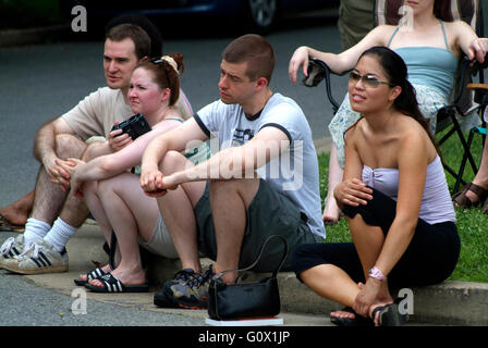 Gruppo di persone sedute su un cordolo e guardare un concerto in Cheverly, Md Foto Stock