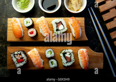 Selezione di sushi compresi i gamberetti, salmone e verdure con riso su blocchi di servizio Foto Stock