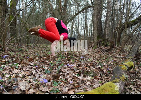 Giovane donna fare yoga asana Bakasana nella foresta di primavera Foto Stock