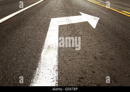 Girare a destra freccia bianca segno sulla strada Foto Stock