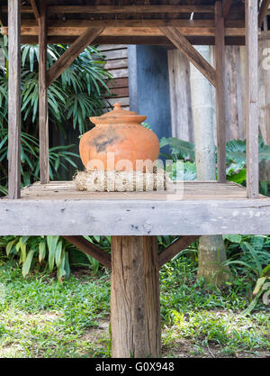 Vecchia pentola di creta per acqua potabile davanti alla casa di campagna, Thailandia. Foto Stock