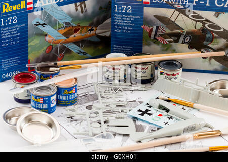 Hobby, kit di plastica modellazione. Sfondo, 2 revell aereo caselle con contenuto di uno in primo piano, circondato dai barattoli di vernice, spazzole e agitatori. Foto Stock