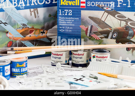 Hobby, kit di plastica modellazione. Sfondo, 2 revell aereo caselle con contenuto di uno in primo piano, circondato dai barattoli di vernice, spazzole e agitatori. Foto Stock