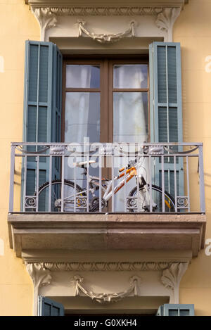 Una moto essendo mantenuta su un balcone del vecchio edificio a Barcellona Spagna Foto Stock