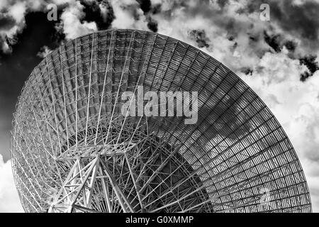 Retro della radio enorme piatto di antenna rivolta verso il cielo nuvoloso in cerca di oggetti spaziali come parte del CSIRO la NASA e la rete di comunicazione. Foto Stock