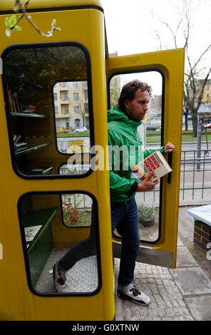 Un uomo proveniente da un libro BucherBoxx exchange booth a Berlino Foto Stock