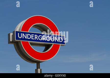 Un metro di Londra segno con un cielo azzurro dietro. Foto Stock