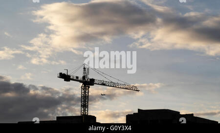 Silhouette di una gru sul sito in costruzione Foto Stock