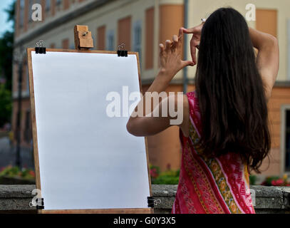 Donna artista rendendo dito telaio nella parte anteriore della tela, Ungheria Foto Stock