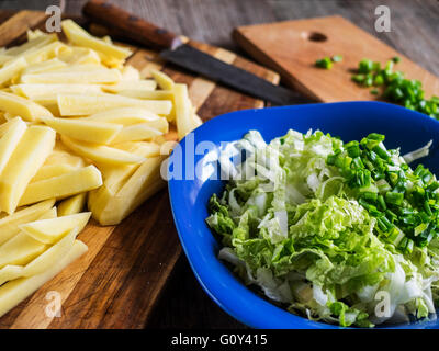 Patate tagliate a fette, cavolo e cipolline Foto Stock