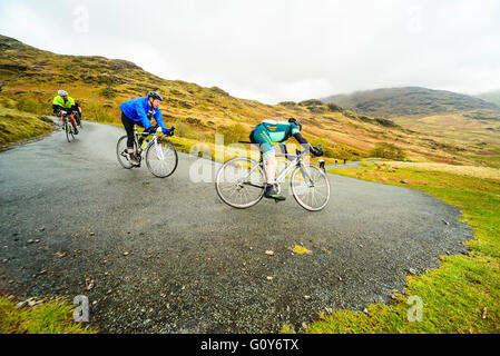 I piloti scendono Hardknott passare durante il Fred Whitton sfida, un 180km/112 miglia di corsa sportiva nel Lake District inglese Foto Stock