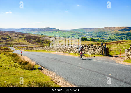 Ciclista femmina sulla salita di Grinton Moor sopra Swaledale nel Yorkshire Dales Foto Stock