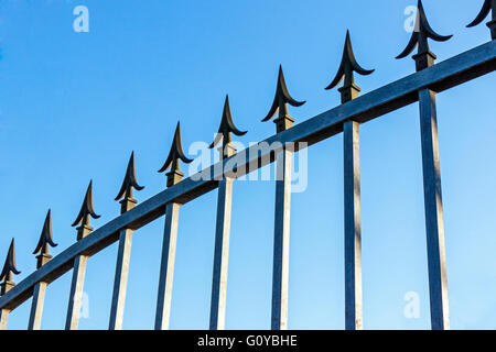 Sicurezza pikes sul cancello zincato contro il cielo blu Foto Stock