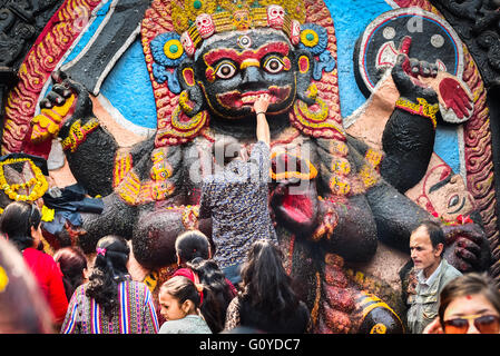 Persone che si rivolgono a pregare all'immagine di Kala Bhairava, celebrando Bishak 1 °--il nuovo anno ufficiale nepalese--a Piazza Durbar, Kathmandu, Nepal. Foto Stock