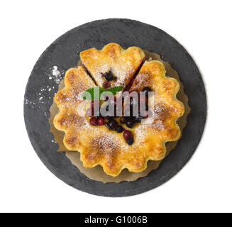 Close up di berry sulla torta moderna piastra di ardesia isolati su sfondo bianco Foto Stock