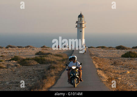 Due giovani motociclisti su una lunga strada di Es Cap de Barbaria faro, a Formentera, isole Baleari. Spagna. Barbaria cape formentera lighthouse road. Foto Stock