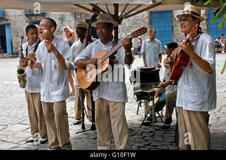 Musicisti suonano ritmi cubani sulle strade di l'Avana. Musica, Havana Vecchia, Cuba. Banda musicale di giocare al di fuori di un ristorante, l'Avana Foto Stock