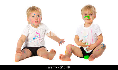 Gemelli fratelli giocando con la vernice, isolato su bianco. Foto Stock