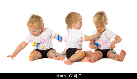 Gemelli fratelli giocando con la vernice, isolato su bianco. Foto Stock