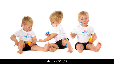 Gemelli fratelli giocando con la vernice, isolato su bianco. Foto Stock