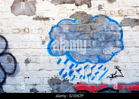 Blue cloud graffiti su un dipinto di bianco muro di mattoni Foto Stock