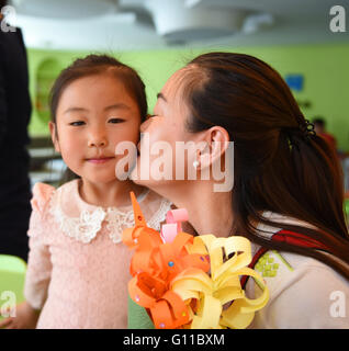 Hohhot. Il 7 maggio, 2016. Una madre bacia la figlia come lei riceve un mazzo di fiori fatti a mano in una campagna detenute per bambini per esprimere la mia gratitudine per le madri a Hohhot, capitale del nord della Cina di Mongolia Interna Regione Autonoma, il 7 maggio 2016, un giorno prima della festa della mamma. © Deng Hua/Xinhua/Alamy Live News Foto Stock