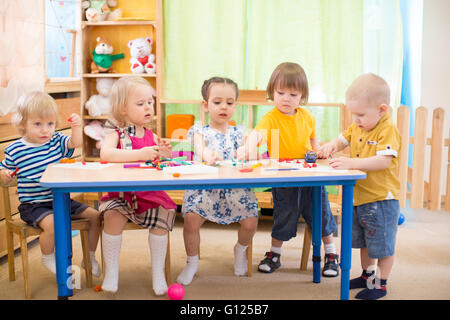 I ragazzi di apprendimento di gruppo arti e mestieri in asilo nido sala giochi Foto Stock