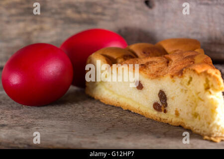 Torta rumena Pasca con formaggio e , colorato tradizionale uovo di pasqua, Sfondo legno Foto Stock