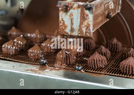 Trasportatore liquido di versamento su dolci. Foto Stock