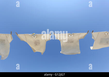 T-shirt bianche, appeso sul stendibiancheria contro il cielo blu Foto Stock