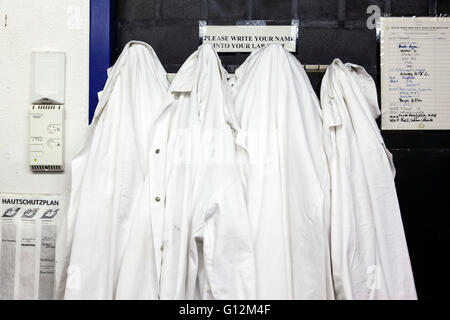 Camici bianchi da laboratorio sul gancio Foto Stock