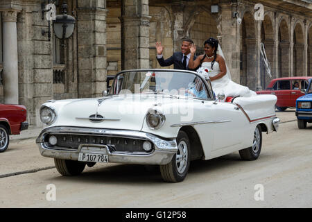 Novelli sposi celebrare il loro matrimonio con un tour di La Habana in una sommità aperta classic car, Paseo de Marti (Prado), Old Havana, Cuba Foto Stock