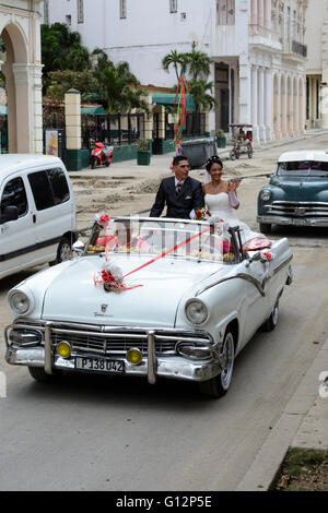 Novelli sposi celebrare il loro matrimonio con un tour di La Habana in una sommità aperta classic car, Paseo de Marti (Prado), Old Havana, Cuba Foto Stock