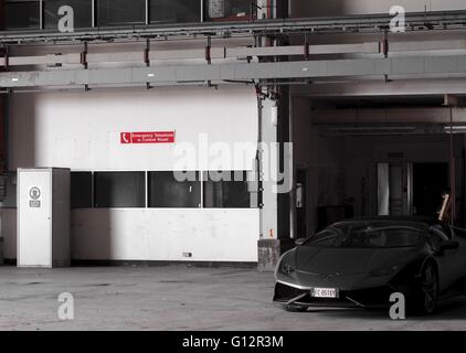 Lamborghini Huracan in magazzino con il segno sulla parete dicendo Telefono di emergenza nella sala di controllo Foto Stock