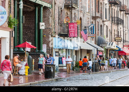 La gente di passeggiata lungo il fiume Street, una zona turistica e il quartiere dello shopping di Savannah, Georgia. Foto Stock
