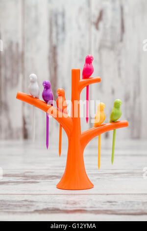 Plastica creativa utensile da cucina. La frutta o dessert bird stuzzicadenti sulla struttura di supporto a forma di supporto Foto Stock