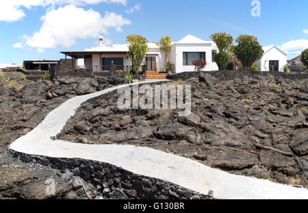Giardino di attraversamento del percorso solidificato o pahoehoe ropey campo di lava a casa, Tahiche, Lanzarote, Isole Canarie, Spagna Foto Stock