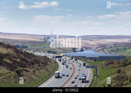 Il traffico passa Booth serbatoio di legno sull'autostrada M62, in una giornata di sole, vicino a Huddersfield, nello Yorkshire, Inghilterra, il 4 maggio 2016 Foto Stock